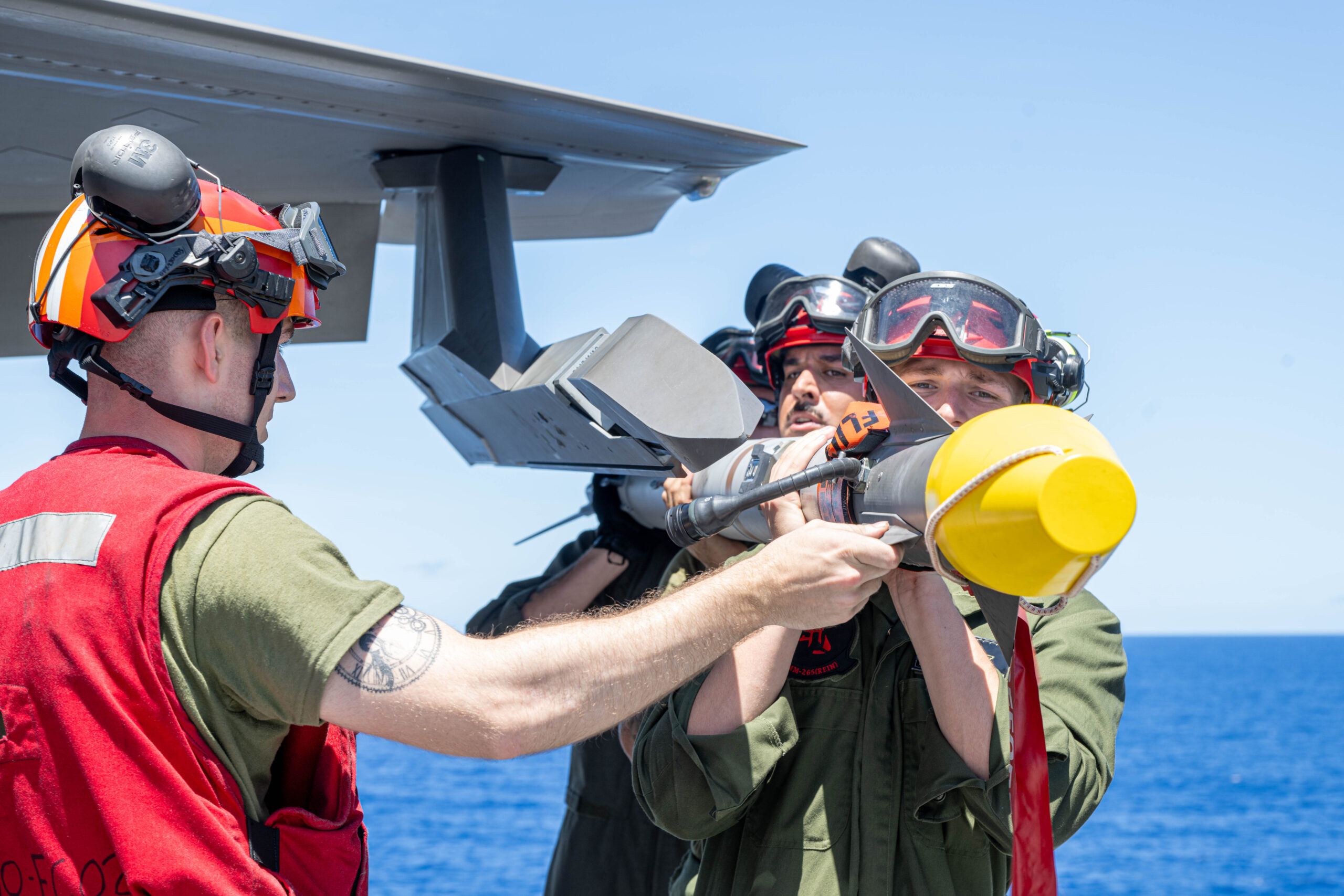 250603-N-FC892-1172PHILIPPINE SEA (June 3, 2025) Marines, assigned to the 31st Marine Expeditionary Unit (MEU), prepare to load an AIM-9X missile on the flight deck of the forward-deployed amphibious assault ship USS America (LHA 6) while in the Philippine Sea, June 3. America, lead ship of the America Amphibious Ready Group, is operating in the U.S. 7th Fleet area of operations. U.S. 7th Fleet is the U.S. Navy’s largest forward-deployed numbered fleet, and routinely interacts and operates with allies and partners in preserving a free and open Indo-Pacific region. (U.S. Navy photo by Mass Communication Specialist 2nd Class Cole Pursley)