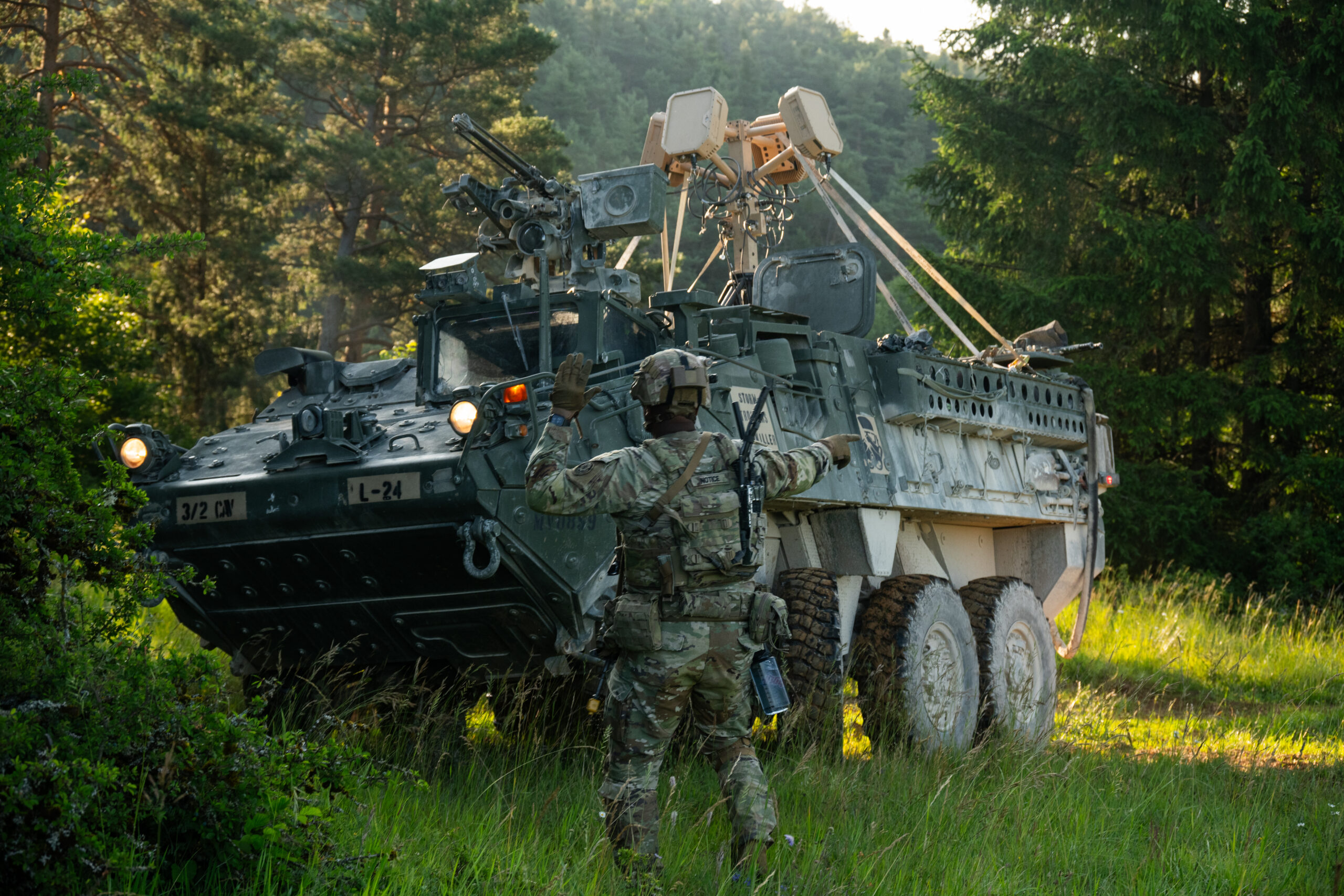 A U.S. Soldier assigned to 3rd Squadron, 2nd Cavalry Regiment guides a Stryker into concealment during Project Flytrap at Joint Multinational Readiness Center, Hohenfels Training Area, Hohenfels, Germany, June 20, 2025. The Soldiers mounted an EchoShield cognitive radar above the Stryker, which detected frequencies of nearby drones and provided ground-force Soldiers with real-time location data on their end-user devices. (U.S. Army photo by Spc. Elijah Magaña)