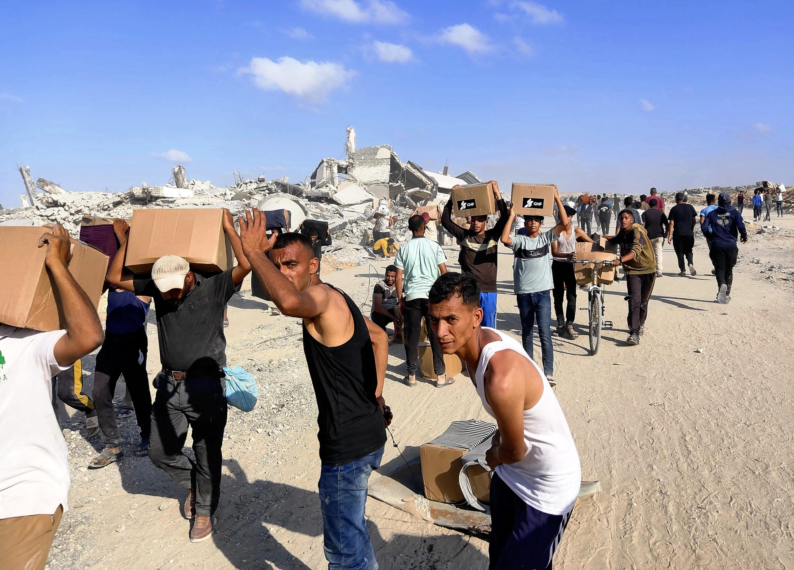 Local residents receive supplies and walk through the destroyed town in Rafah, the southernmost part of Gaza Strip, on May 29, 2025. The distribution of aid led by Israel and United States of America began in Rafah, on the same day. Crowds rushed to the site, and according to the Middle Eastern satellite television station Al Jazeera, at least three people were killed and 46 were injured by Israeli gunfire. ( The Yomiuri Shimbun ) (Photo by YOMIURI SHIMBUN / Yomiuri / The Yomiuri Shimbun via AFP)