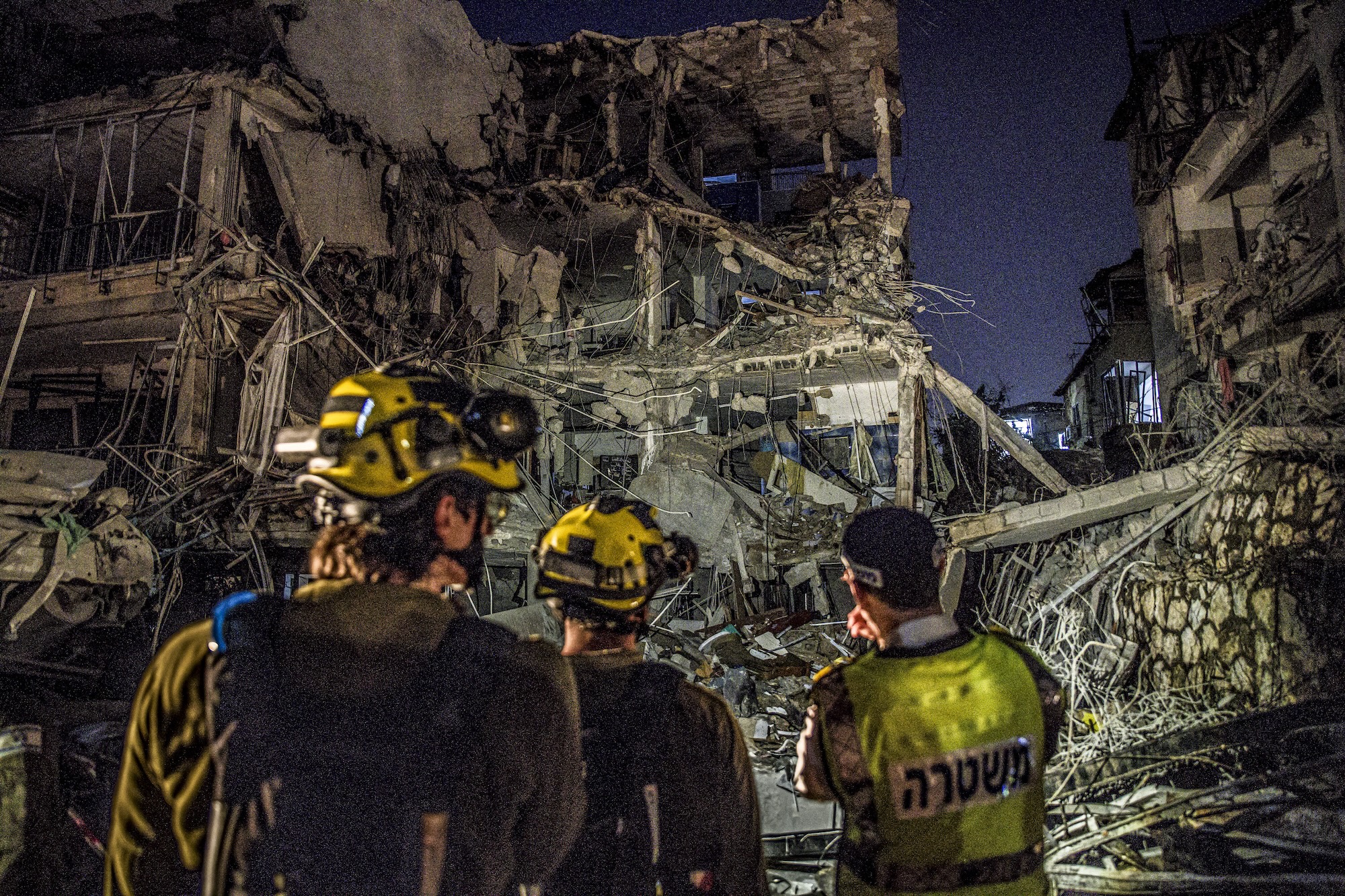 Rescue workers inspect the remains of a building hit by an Iranian missile in Tel Aviv, Israel, on June 13, 2025