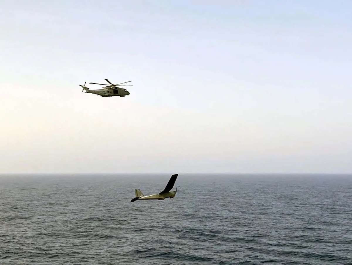 The Royal Navy's Merlin helicopter flying above the Puma drone over the ocean
