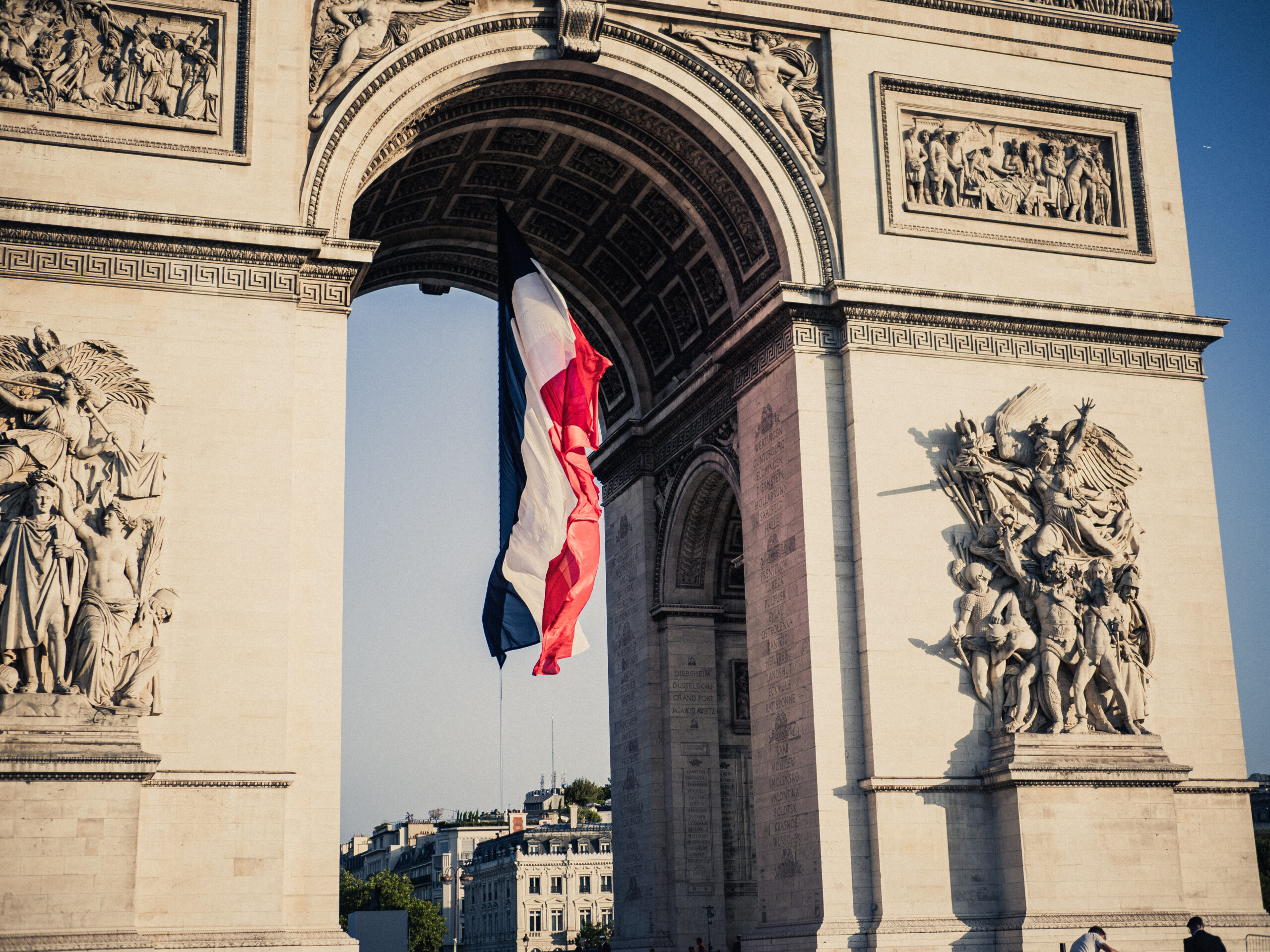 A French flag under the Arc de Triomphe during the preparation of the annual Bastille Day military parade on the Champs Elysees avenue in Paris France on July 14, 2025. (Photo by Bastien Ohier / Hans Lucas via AFP)