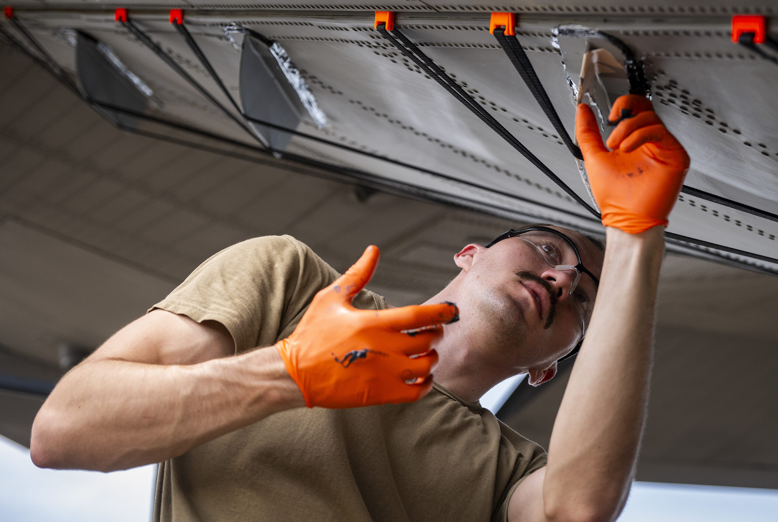 Airman 1st Class Tustin Bridges, 1st Special Operations Wing, secures a 3D-printed Finlet onto the rear door of an MC-130J at Eglin Air Force Base, Florida