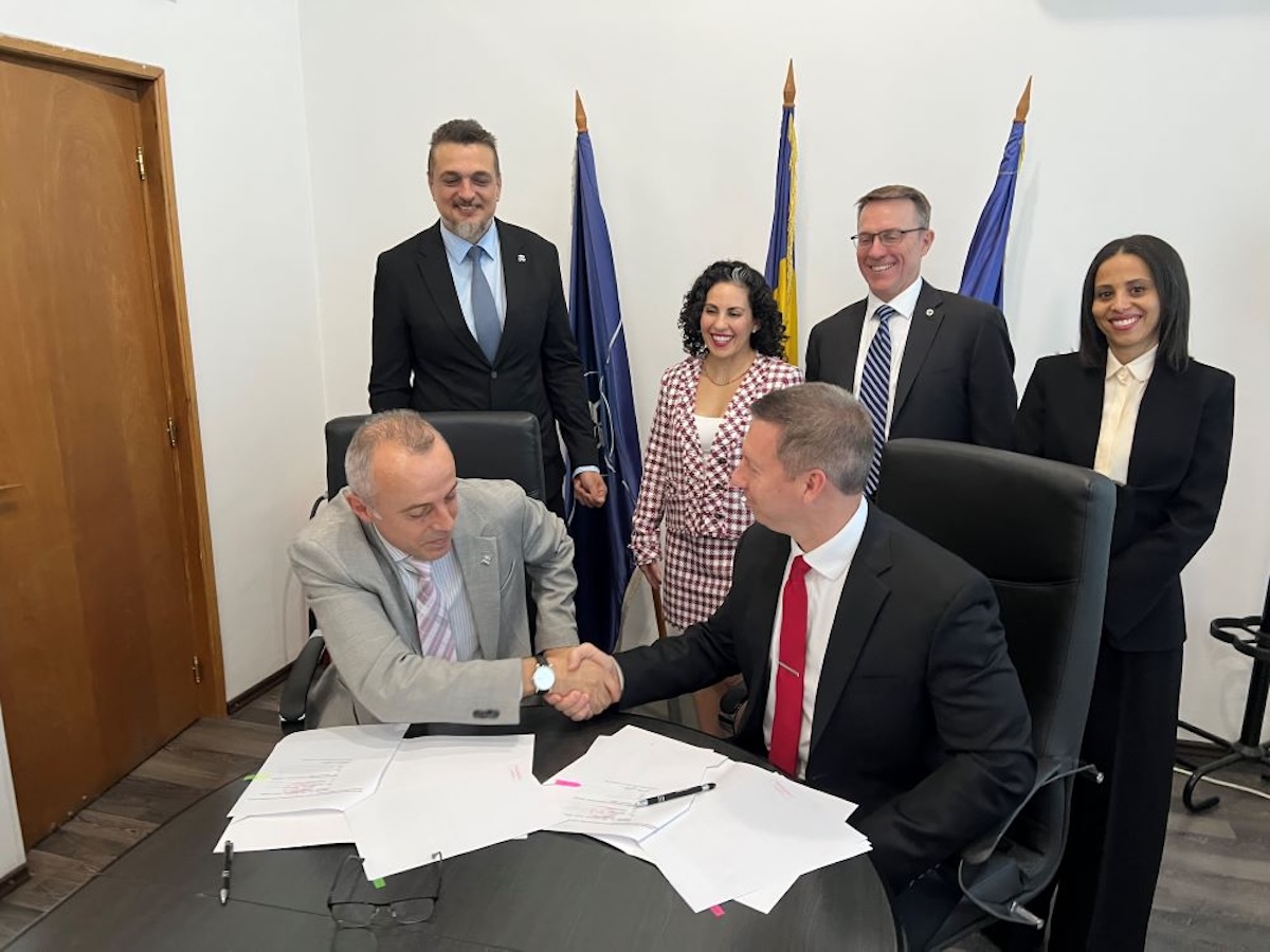 Northrop Grumman and ROMARM officials shake hands after signing a memorandum of understanding
