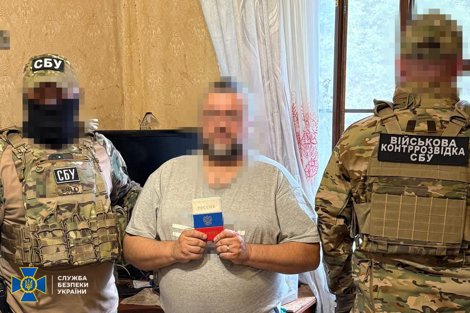 A Russian spy holding passport with Ukrainian security agency personnel. Photo: Ukrainian Security Service