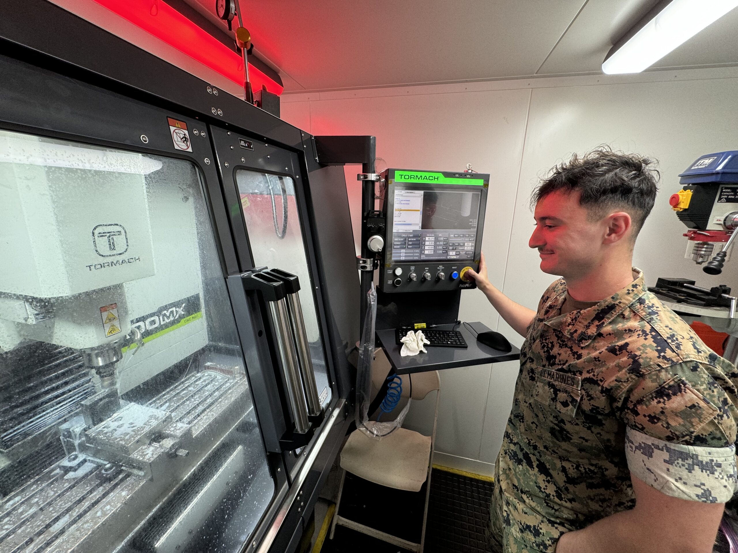 240725-N-ZZ999-2502 KANEOHE BAY, Hawaii (July 25, 2024) U.S. Marine Corps Cpl. Martin Lauterman, assigned to Combat Logistics Company (CLC) 33 at Marine Corps Base Hawaii, operates the milling machine in the SPEE3D Cell to complete a stainless steel part during Exercise Trident Warrior 2024. The exercise brought together personnel from the Naval Postgraduate School, the Marine Innovation Unit, FLEETWERX and industry to demonstrate advanced manufacturing technology in an expeditionary scenario. (U.S. Navy photo)