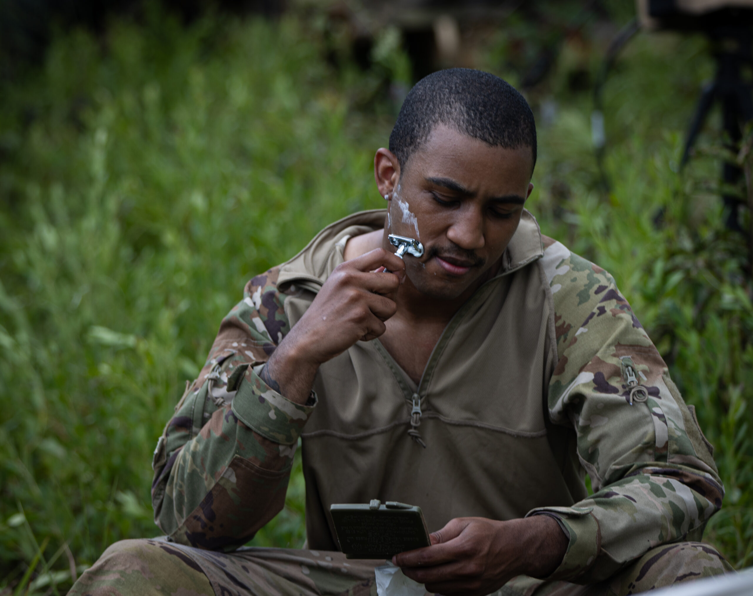 1st Lt. Jean Paul Stassi Jr., battalion IT support officer, shaves in the field before starting training, Camp Shelby, July 24, 2024. The overall focus of the unit's annual training was to instill the fundamentals and proficiency of battalion, company, and squad level operations. (U.S. Army National Guard photo by Staff Sgt. Jaccob Hearn)