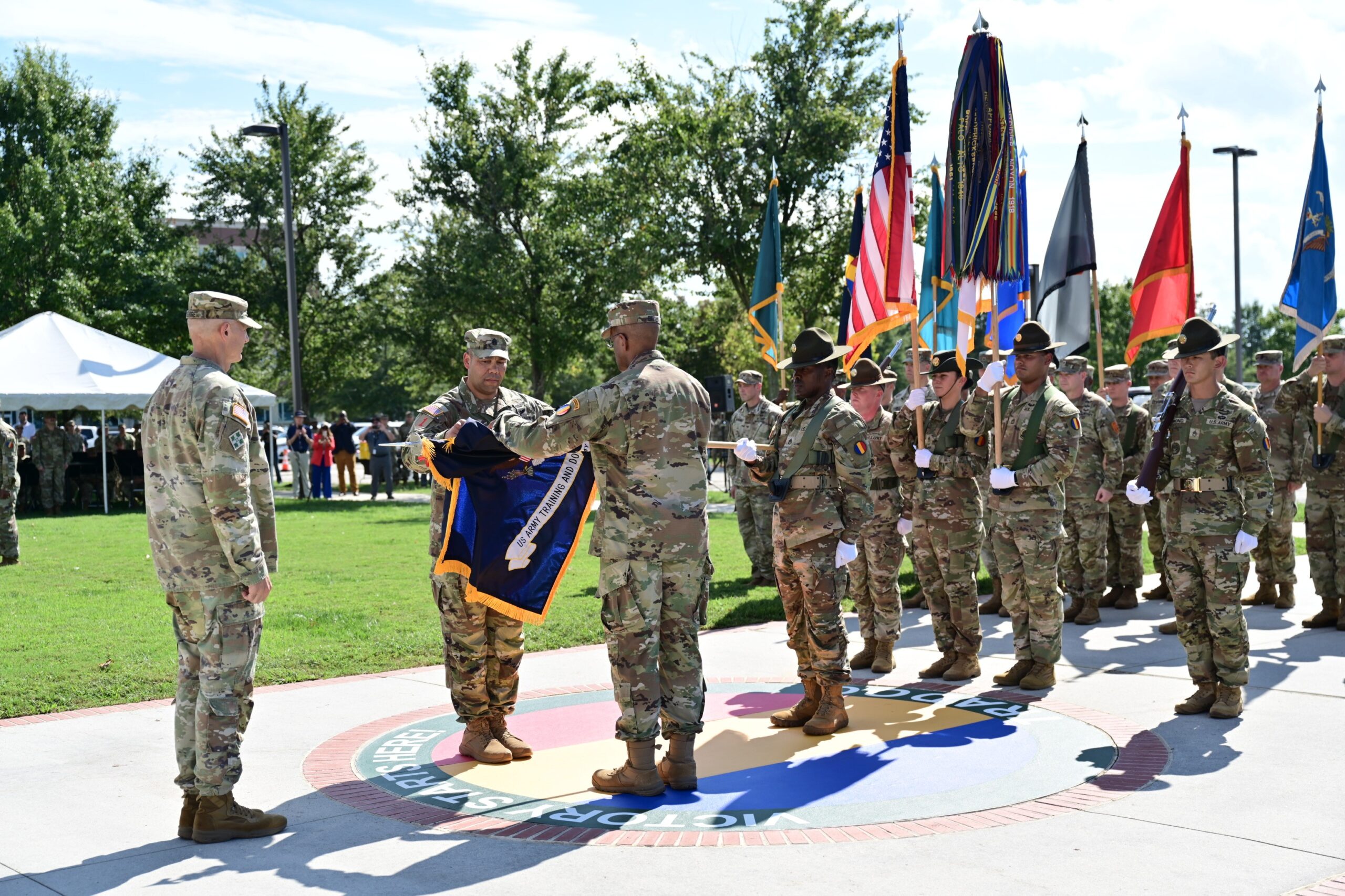 Gen. Gary M. Brito, TRADOC commanding general, and Command Sgt. Maj. Raymond S. Harris, TRADOC command sergeant major, case the TRADOC colors at the TRADOC inactivation ceremony. (US Army Photo by Jean Wines.)