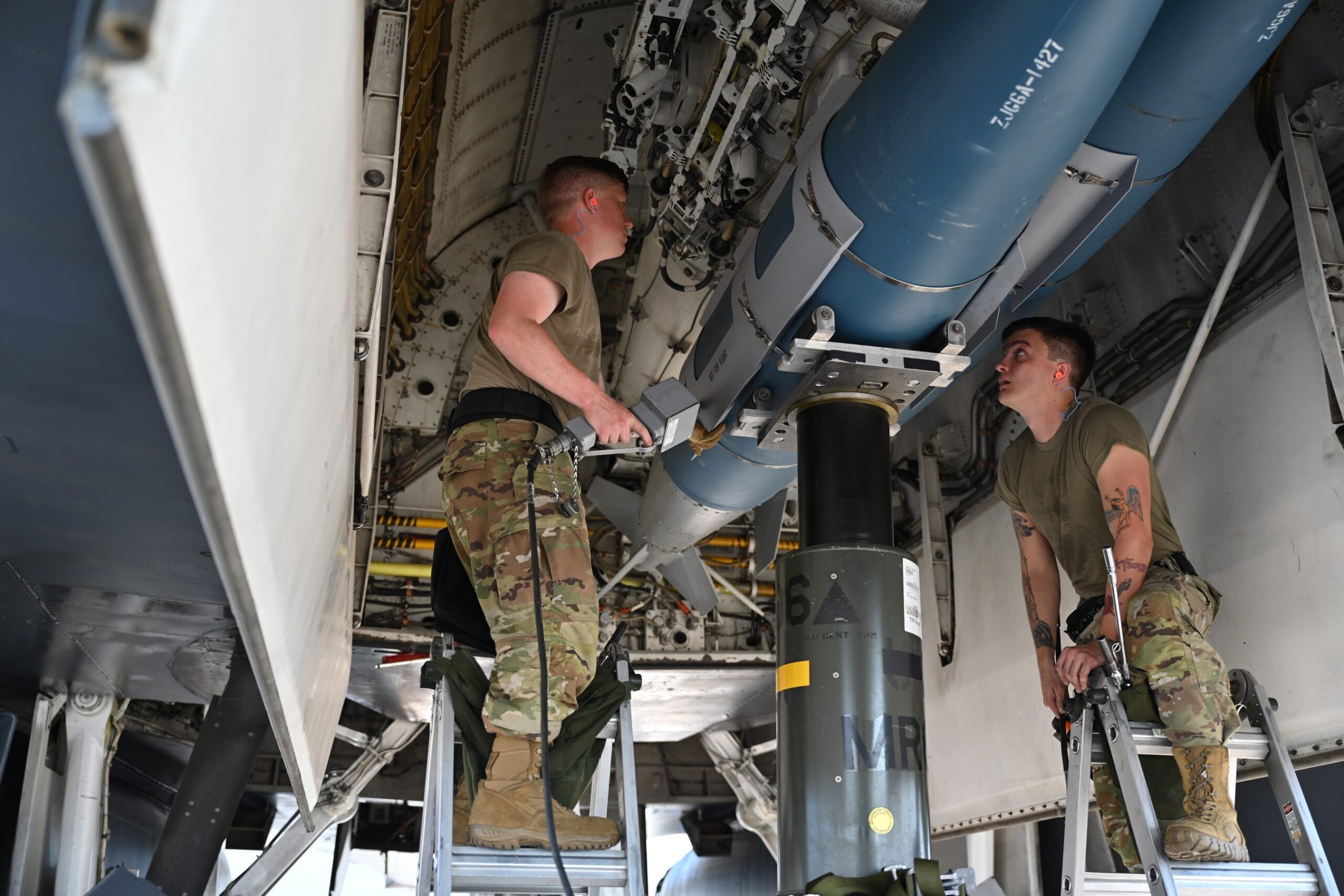 Members of the 28th Aircraft Maintenance Squadron weapons load crew insert an inert joint air-to-surface standoff missile into a B-1B Lancer.