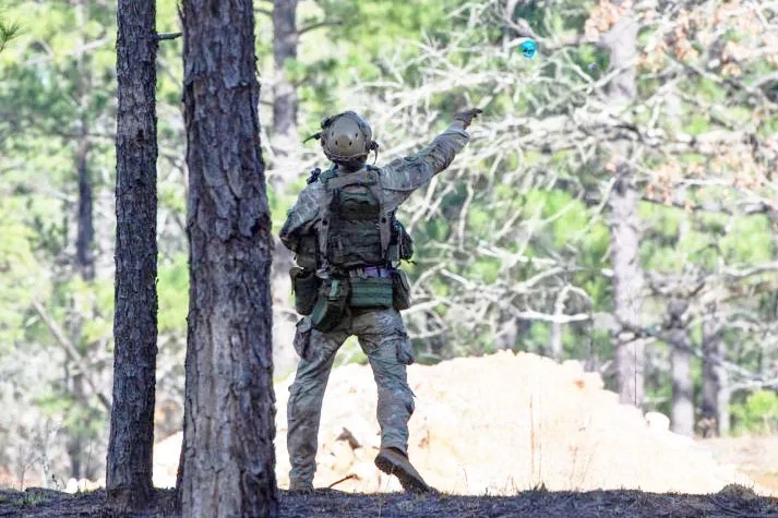 A soldier tosses a Sim Grenade in operational testing at the Joint Readiness Training Center
