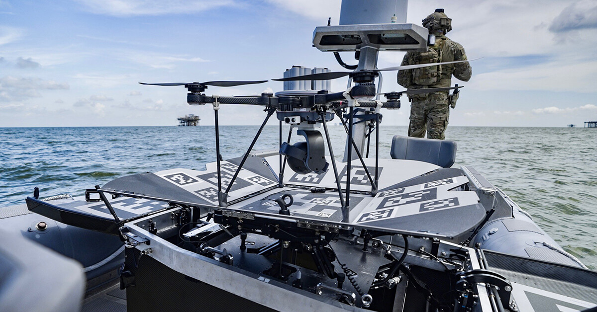 The SkyCarrier carrying a drone at sea with a soldier in the background