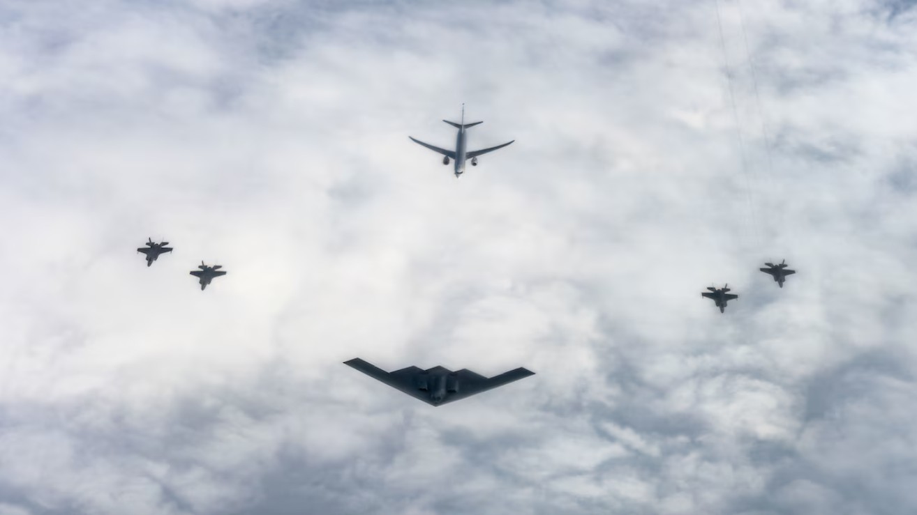 A US Air Force B-2 Spirit, center, from the 72nd Test and Evaluation Squadron assigned to the 53rd Wing, a Royal Norwegian Air Force P-8 Poseidon, center back, and four Royal Norwegian Air Force F-35 Lightning II, right and left, fly in formation over Norway.