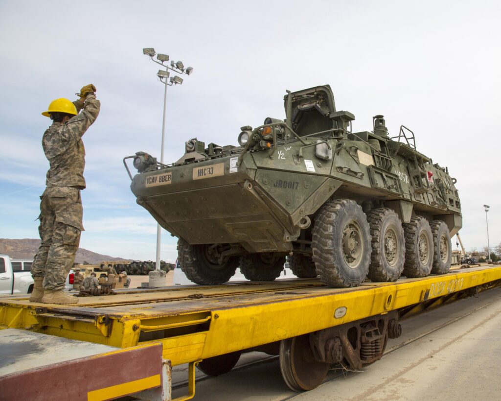 Students in the Railway Operations Group Training Course practice using hand signals to direct US Army equipment during loading and unloading operations at the Yermo Annex, Marine Corps Logistics Base Barstow, California