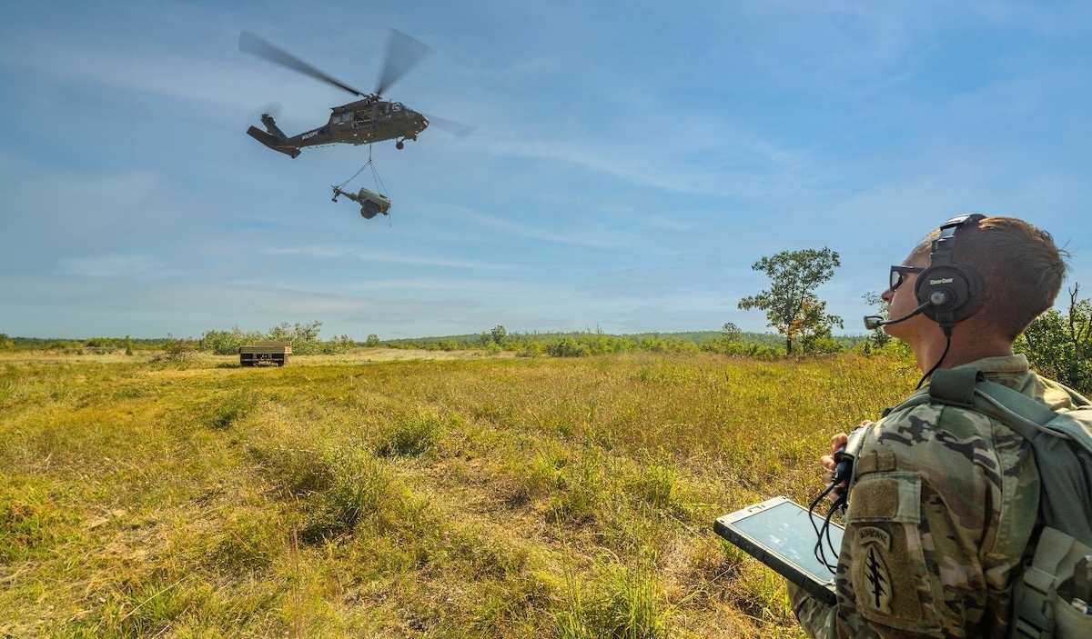 U.S. Army National Guard Sgt. uses a tablet to command the Sikorsky OPV Black Hawk to autonomously transport a 2,900-pound water buffalo sling load for the first time during Northern Strike in Michigan.