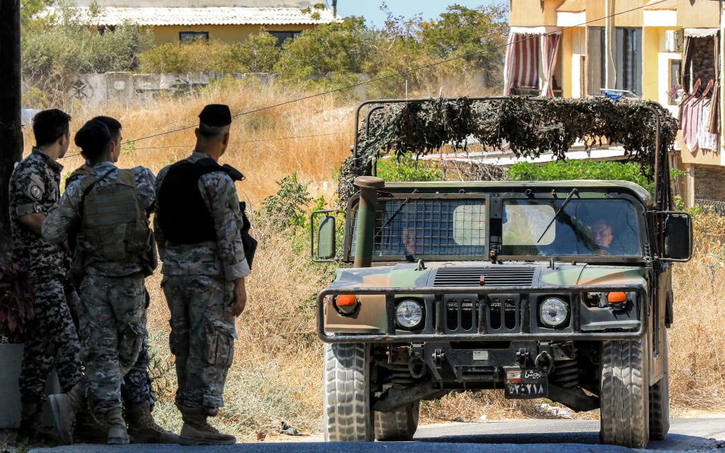 A Lebanese army vehicle approaches soldiers stationed near the Ain al-Hilweh camp for Palestinian refugees in Lebanon's southern city of Sidon.