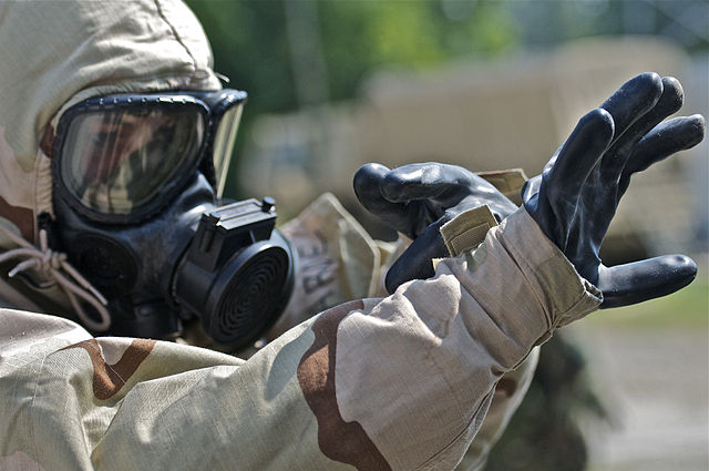 Soldier wearing protective gear assisting in the decontamination process after a dirty bomb explosion