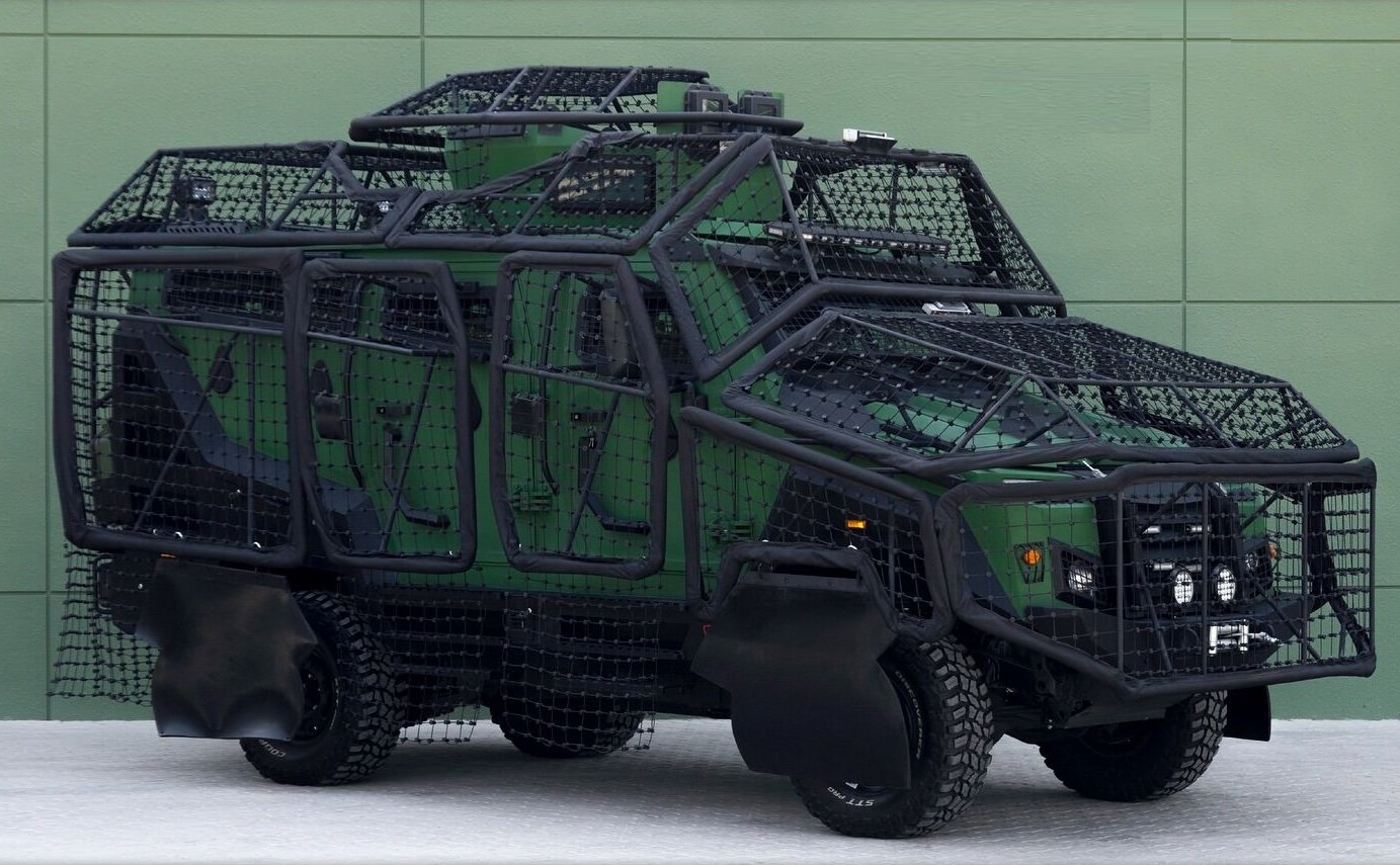A well lit image of the Jedi armored vehicle covered by the Q-Net system in front of a green wall background