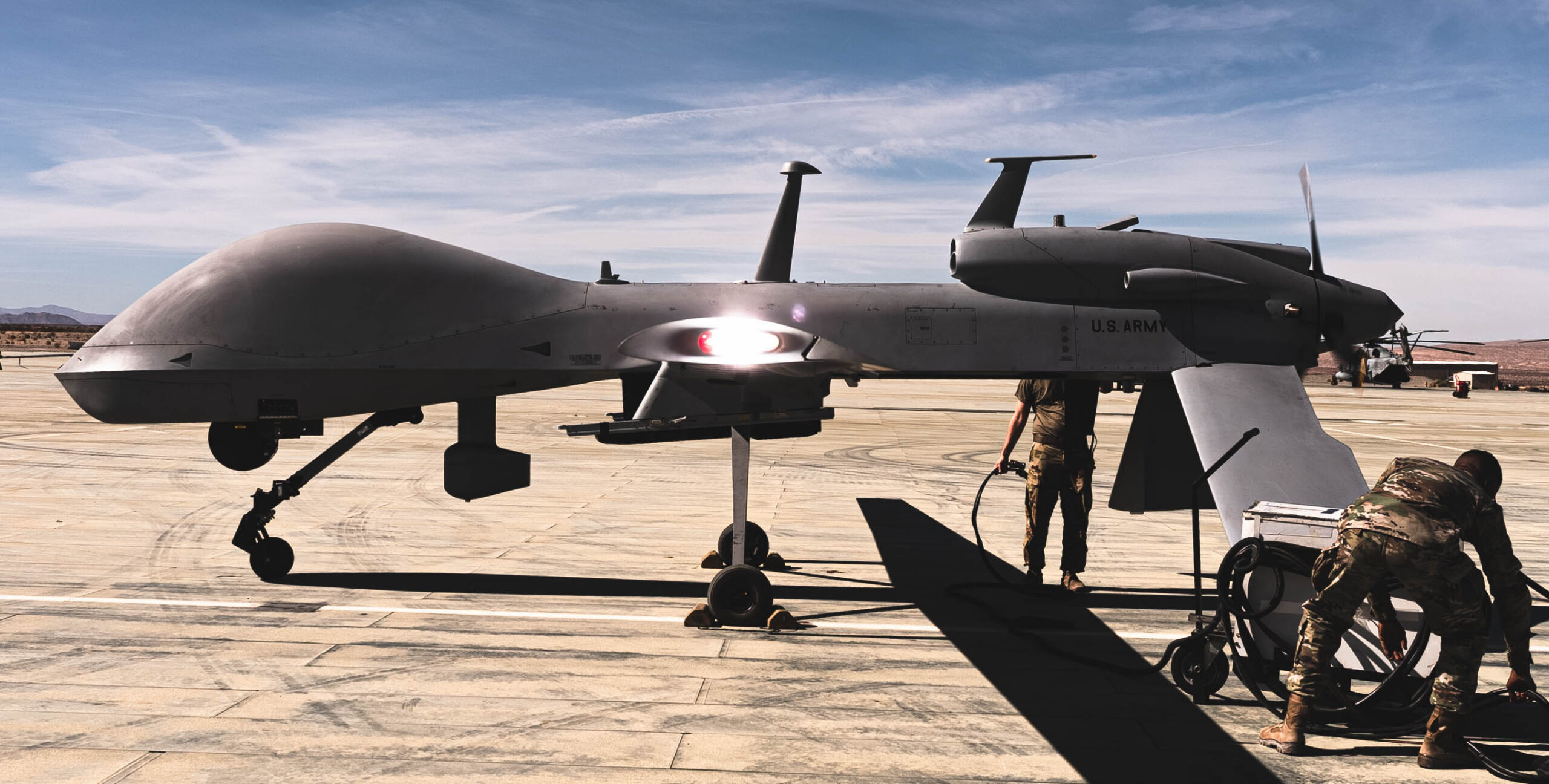 U.S. Army soldiers with 1st Attack Reconnaissance Battalion, 1st Aviation Regiment, 1st Combat Aviation Brigade, 1st Infantry Division, conduct pre-flight checks on an MQ-1C Gray Eagle during the Battalion Distributed Operations Course at Marine Corps Air Ground Combat Center, Twentynine Palms, Oct. 20, 2021. The soldiers integrated seamlessly with U.S. Marines on the ground and in the sky, providing ground commanders with superior reconnaissance, overwatch, and marking targets by laser for the Aviation Combat Element whilst maintaining the ability to utilize their own AGM-114 Hellfire Missile. (U.S. Marine Corps photo by Lance Cpl. Shane T. Beaubien)