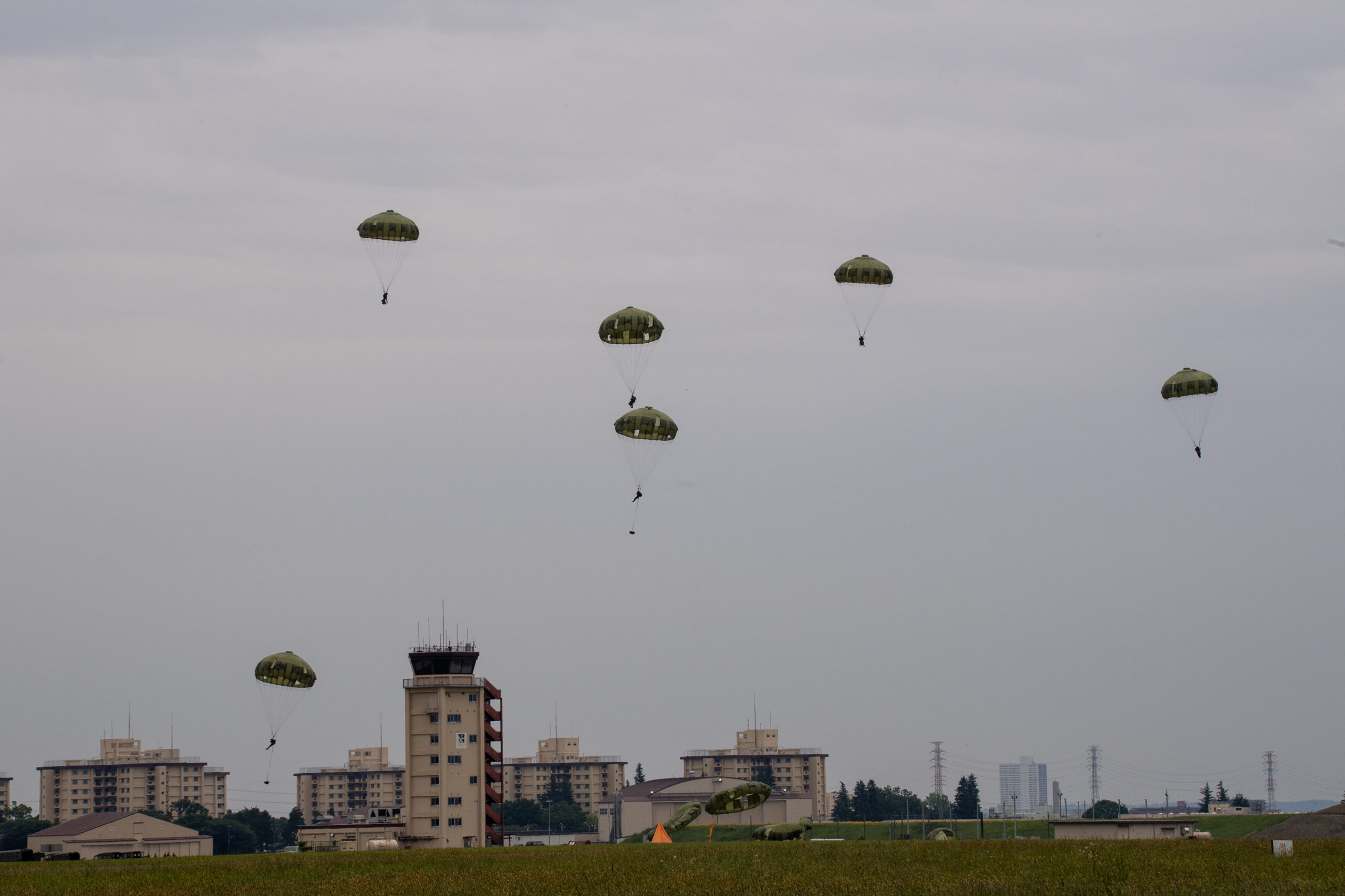 Japan Ground Self-Defense Force paratroopers with the 1st Airborne Brigade and descend after jumping from a U.S. Air Force C-130J Super Hercules assigned to the 36th Airlift Squadron during the Japanese-American Friendship Festival 2024 at Yokota Air Base, Japan, May 19, 2024. The JGSDF 1st Airborne brigade conducted HALO and static-line jump demonstration to show their capabilities during the festival. The festival is aimed at increasing bilateral relationships between U.S. and Japanese communities and allows people to see U.S. and Japanese military capabilities first-hand. (U.S. Air Force photo by Yasuo Osakabe)