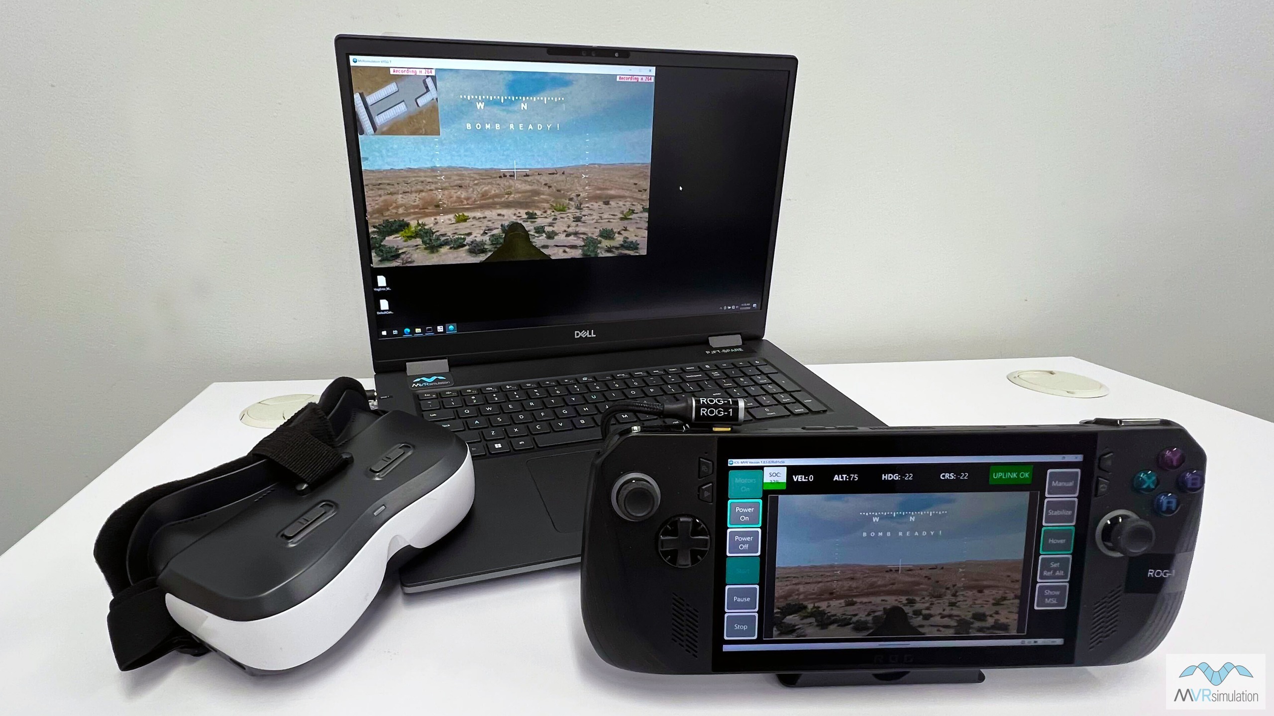 A laptop with a VR headset and game controller, set up for an FPV simulator experience.