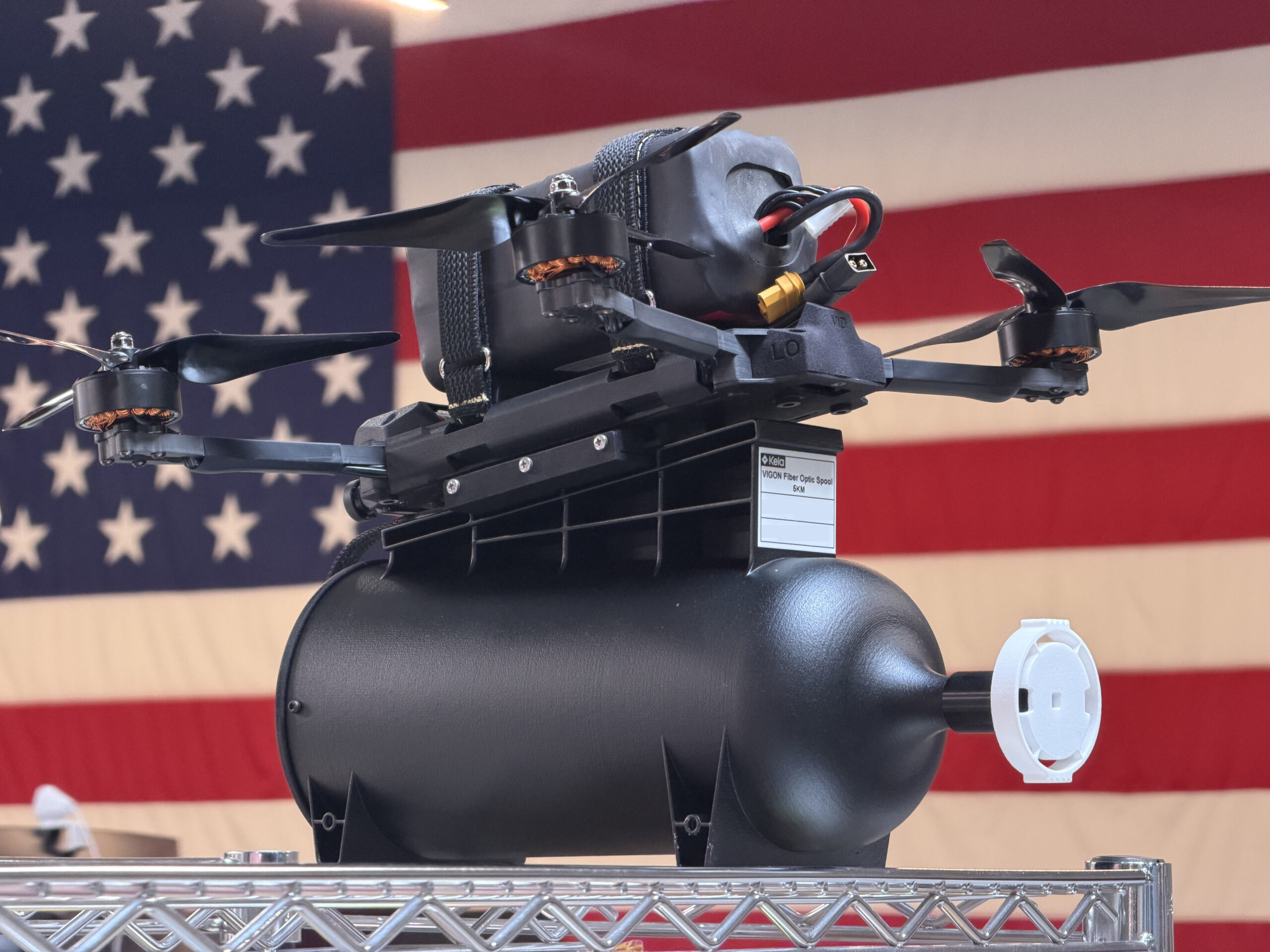 The Archer Fiber fiber-optic, FPV drone posed in front of the United States flag