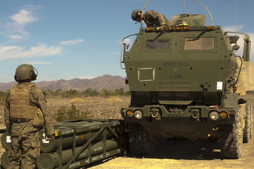 US soldiers with GMLRS munitions placed side by side with the M142 High Mobility Artillery Rocket System