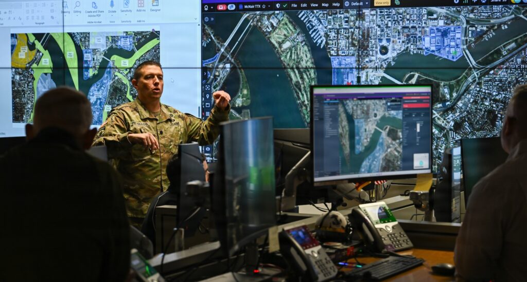 Lt. Col. Brian Reynolds explains the counter-unmanned aircraft system exercise drone path on a map to interagency partners at Fort McNair, Washington, DC