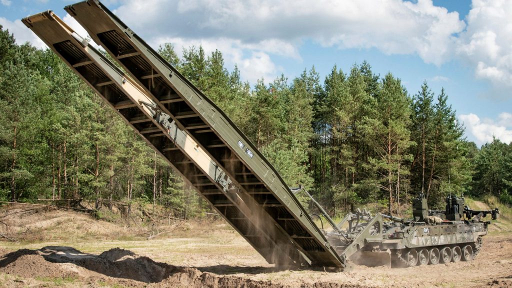 Pictured:TITAN Armoured Vehicle Launching Bridge (No 12 Close Support Bridge) to span a ditch. British units are again exercising at Bergen-Hohne Training Area after a four-year absence. The Royal Welsh Battle Group conducted live-firing and armoured manoeuvre training as part of a validation process to test its readiness. This is part of a programme designed by the Combat Ready Testing Centre (Germany). The Royal Welsh Battlegroup is a mix of armoured fighting formations and supporting units, including the Challenger 2 Main Battle Tanks, Warrior armoured infantry vehicles, Royal Artillery Field Guns, armoured engineers and medical, logistical, signal and repair specialists. The exercise tests their interoperability and fine-tunes processes. Several hundred vehicles were transported to the Bergen-Hohne by rail and road, testing the deployable capability and the concept of the Forward Holding Base in Sennelager. The next phase of the exercise will be in August in Altmark, the German Army’s operational deployment and testing centre, including the use of the modern urban training facility. It will be the first time a British Battlegroup will train there