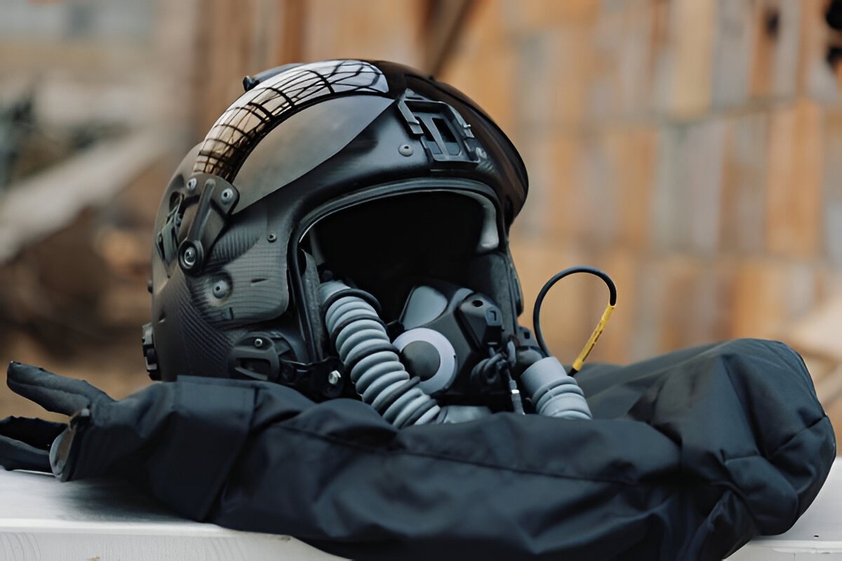 Gentex PURSUIT flight helmet for the US Navy, shown with integrated oxygen mask, visor, and communications gear resting on a padded surface during a press display.