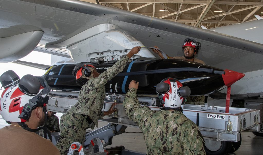 Sailors prepare to transport an AGM-158C Long Range Anti-Ship Missile (LRASM) on board a P-8A Poseidon