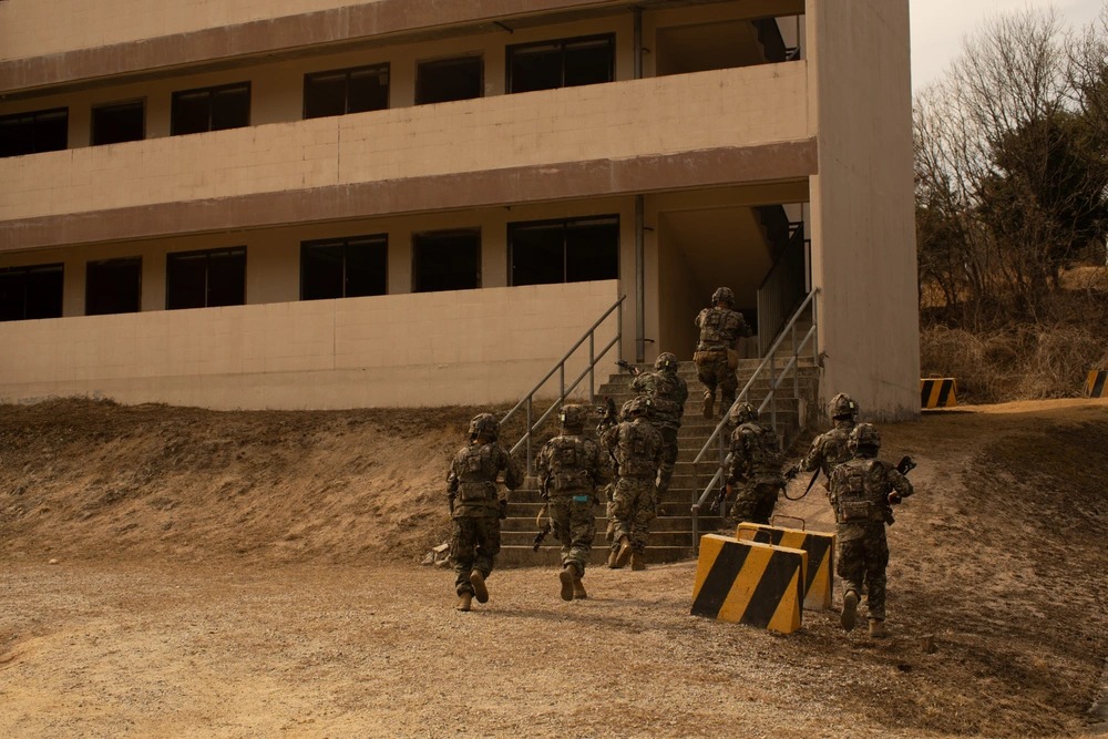 Military personnel training at a concrete facility, highlighting the vulnerability of buildings and windows to electromagnetic threats.