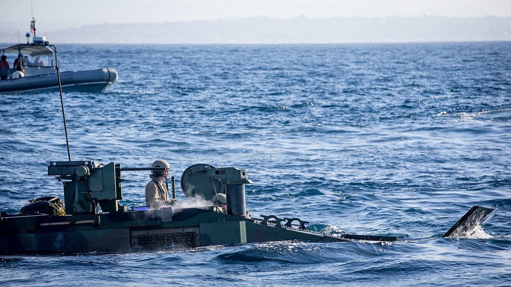 A U.S. Marine maneuvers an Amphibious Combat Vehicle into the amphibious transport dock ship USS Somerset