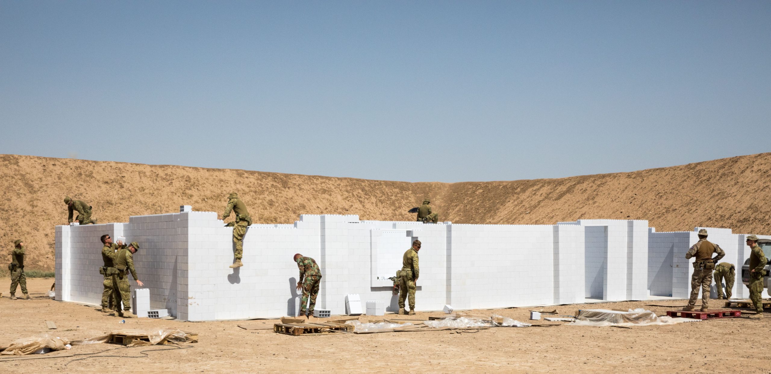 Australian and New Zealand soldiers with Task Group Taji, with the assistance of Iraqi instructors from the School of Infantry NCO II, install a new modular Urban Training Facility on Camp Taji, Iraq, June 2, 2019. The new training facility made of hardened plastic bricks will last much longer and allow for greater variety of training options than the wooden facades they are replacing. The Coalition focuses on providing training support, and equipment to enhance the professionalism, technical expertise and equipment capabilities of Iraqi Security Forces. (U.S. Army Reserve photo by Cpl. Tamara Cummings)