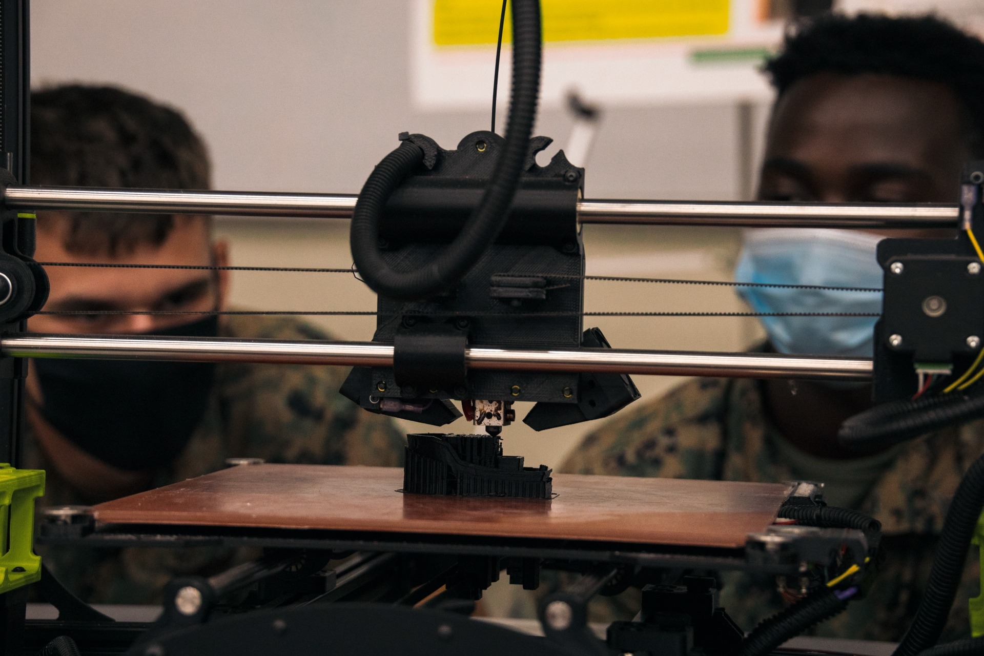 U.S. Marine Corps Lance Cpl. Ryan Teets, left, a motor transportation mechanic, and Lance Cpl. Volcy Voltaire, a generator mechanic with Marine Air Control Squadron 1, 3rd Marine Aircraft Wing, watch a Lulz Bot Taz 6 build a 3-D object during an innovation roadshow on Camp Pendleton, California, July 20, 2022. The Digital Manufacturing Platoon hosts innovation roadshows to showcase 3-D printing capabilities which can provide a means of optimizing readiness by reducing equipment and maintenance requirements. These capabilities support 1st MLG’s mission to provide naval force commanders with the greatest number of options for operational planning and tactical execution. (U.S Marine Corps photo by Lance Cpl. Kristy Ordonez Maldonado)