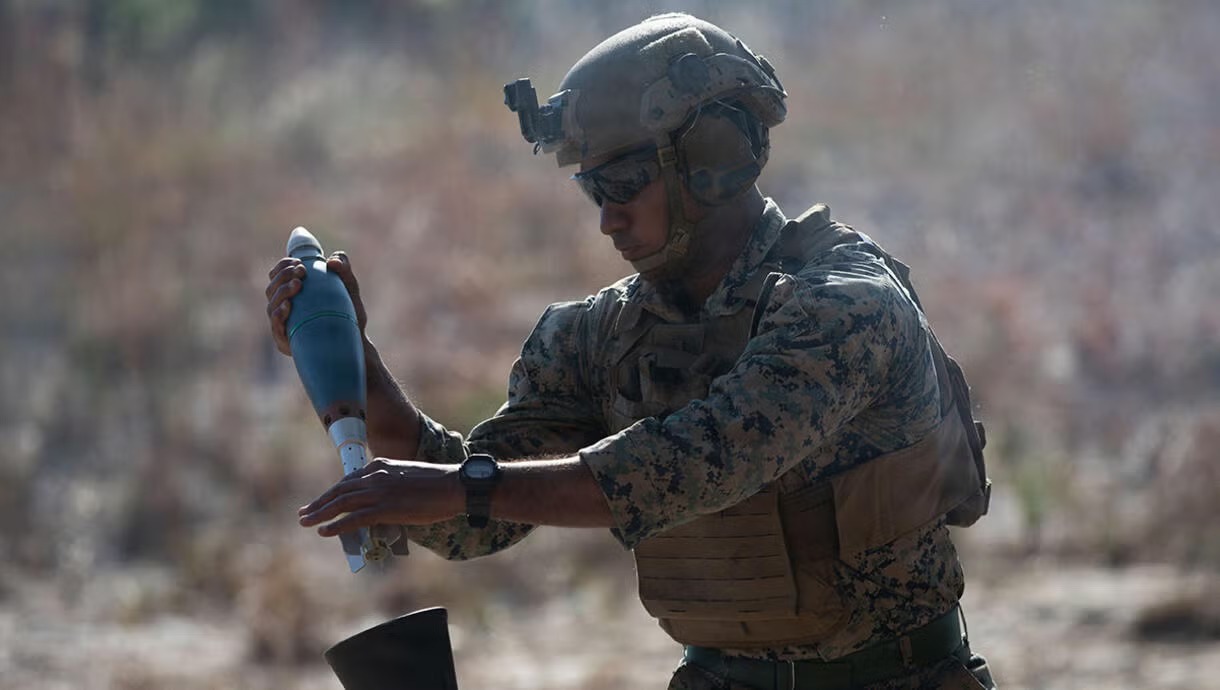 A US Marine loads a round in an 81mm mortar system.
