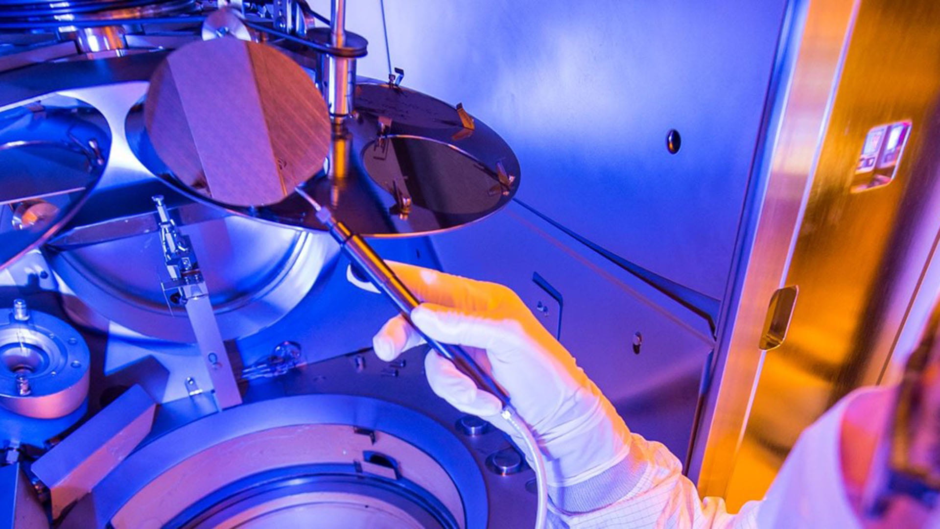 Personnel lifting a thin-film lithium niobate (TFLN) wafer