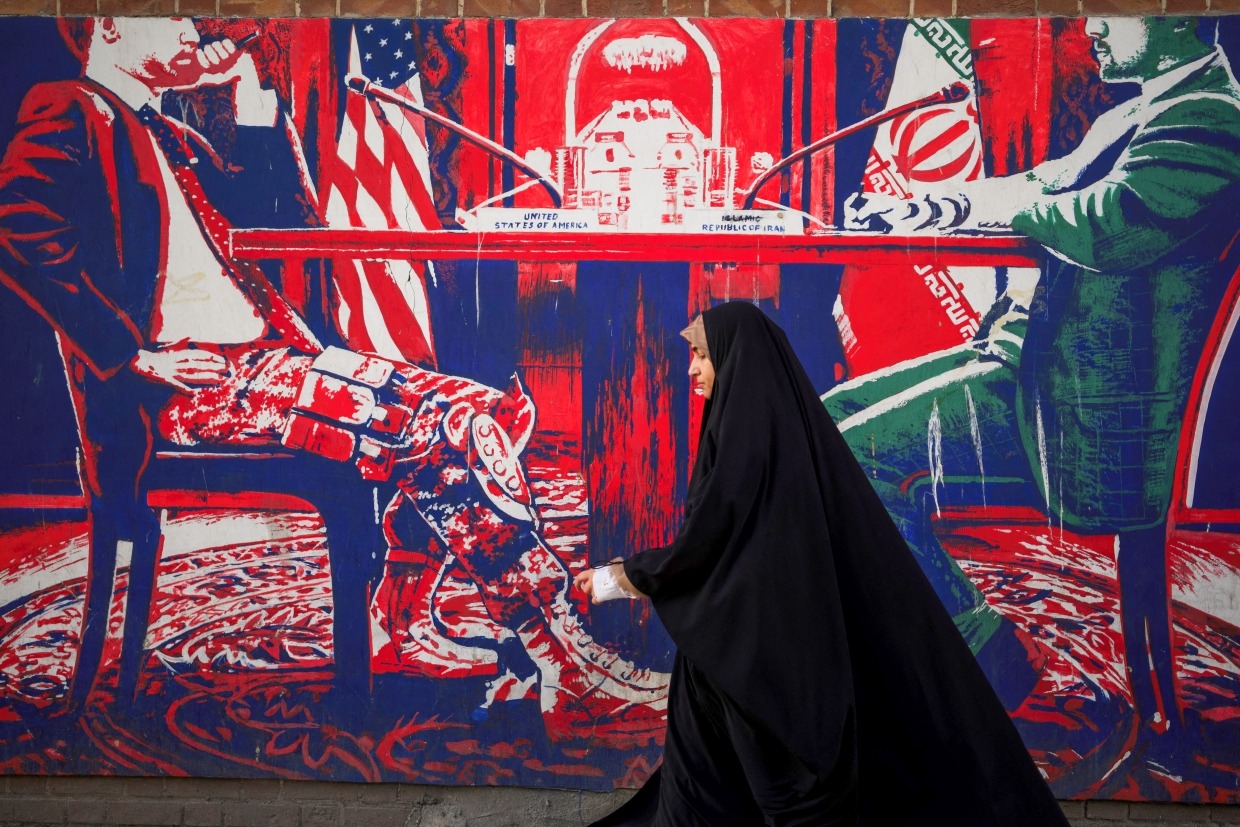 Iranians pass by the anti-American murals painted on the walls of the former embassy of the US in Tehran, Iran on April 16, 2025.