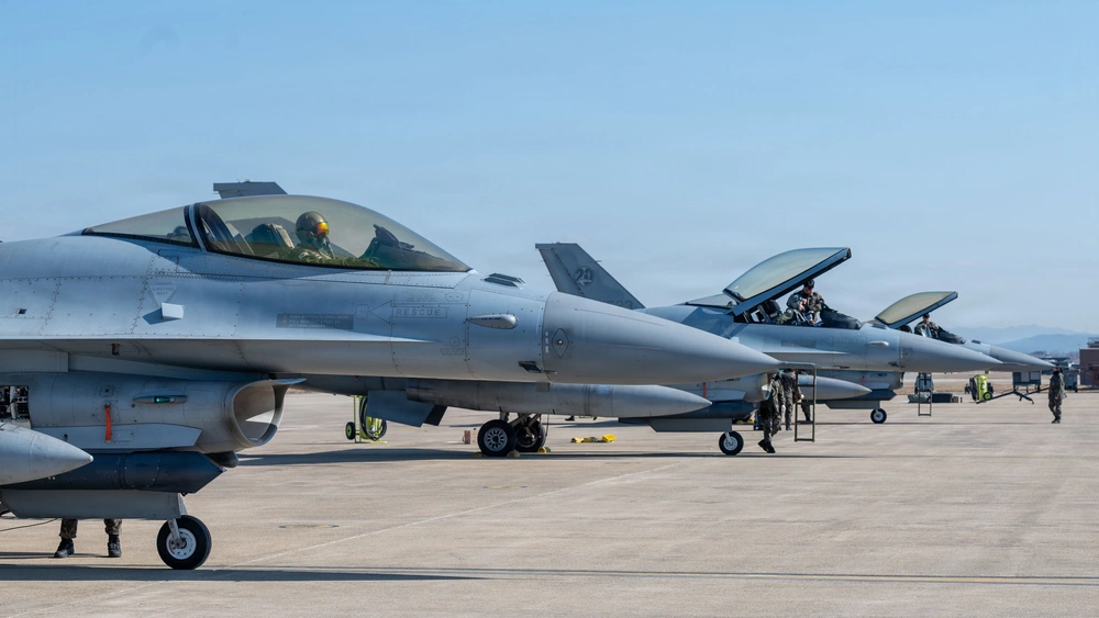 ROKAF KF-16 fighter jets lined up on runway at Osan Air Base with pilots in cockpit