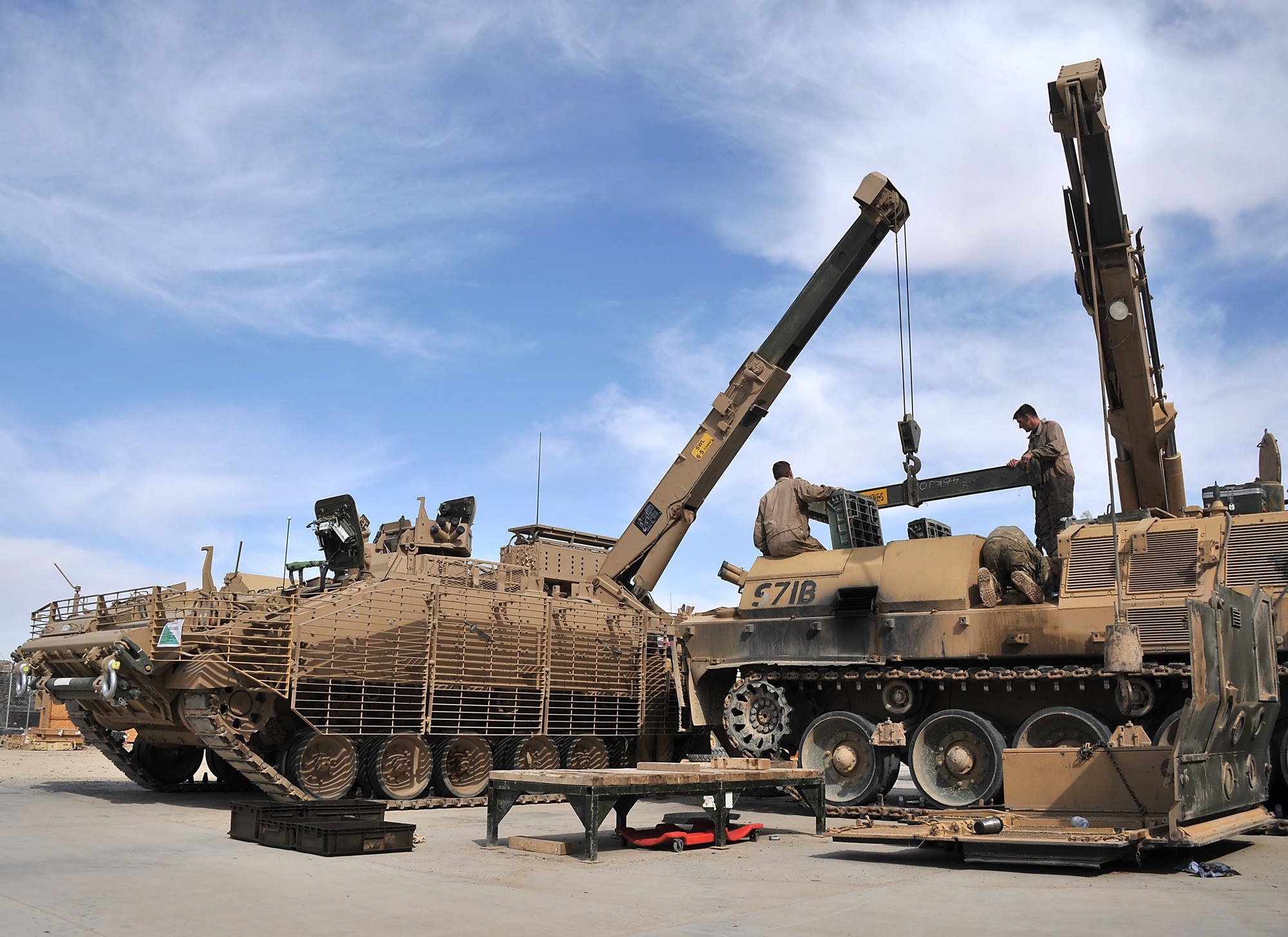 Pictured are REME Vehicle Mechanics from ES Bn (Equipment Support Battalion) changing a Power Plant on a CRARRV (Challenger Armoured Recovery Repair Vehicle) using a second CRARRV during Op Herrick 15. The Challenger Armoured Repair and Recovery Vehicle (CRARRV) is a highly evolved armoured vehicle designed to recover and repair damaged tanks on the battlefield. The vehicle has two winches, main and auxiliary, and an Atlas hydraulically operated crane capable of lifting a complete Challenger 2 power pack. A modern, high-tech Army needs highly trained men and women to keep equipment working. The role of the Royal Electrical and Mechanical Engineers (REME) is to do just that; maintain, repair and manufacture equipment to keep battle winning aircraft, tanks and weapons in fighting order. The REME exists to Ôkeep the punch in the ArmyÕs fistÕ. Every part of the British Army has a REME detachment within it allowing opportunity around the world from Belize, to Canada, to Cyprus, to Kenya. REME has a set ofÊeight trades: Armourer, Recovery Mechanic, Avionics Technician, Electronics Technician, Metalsmith, Vehicle Mechanic, Aircraft Technician and Technical Support Specialist. From repairing Challenger tanks at the forefront of the battle to maintaining the Apache Attack Helicopter, REME keeps up to date with the latest in advanced technologies and complex equipment, constantly evolving our training programme to make the seemingly impossible possible.