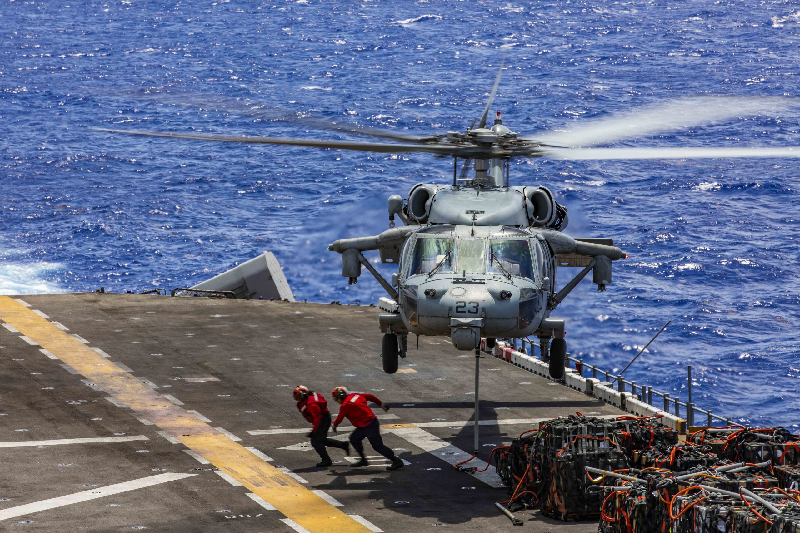 190710-N-ZH865-1250 ATLANTIC OCEAN (July 10, 2019) Sailors clear the flight deck aboard the Wasp-class amphibious assault ship USS Kearsarge (LHD 3) after attaching a pallet of ordnance to an MH-60S Sea Hawk helicopter during an ammunition offload. Kearsarge is the flagship for the Kearsarge Amphibious Ready Group. The Kearsarge ARG is deployed in support of maritime security operations, crisis response and theater security cooperation, while providing a forward naval presence. (U.S. Navy photo by Mass Communication Specialist Seaman Vincent Zaragozi/Released)