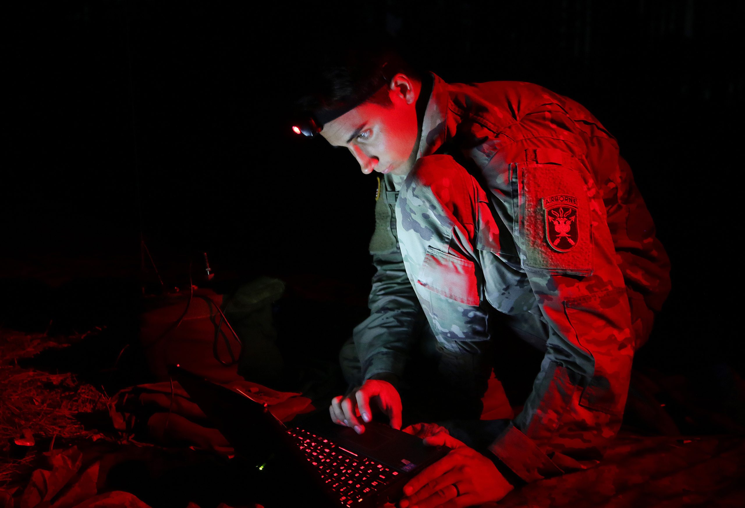 A student assigned to the U.S. Army John F. Kennedy Special Warfare Center and School, who is in the Special Forces Communications Sergeant course, uses a PDA-184 computer during nighttime antenna training at Fort Bragg, North Carolina August 30, 2019. The training qualified students in the high frequency communications module which trained them to be proficient in making, installing, operating and maintaining short-, medium-, and long-range antennas in order to communicate at long distances. (U.S. Army photo by K. Kassens)
