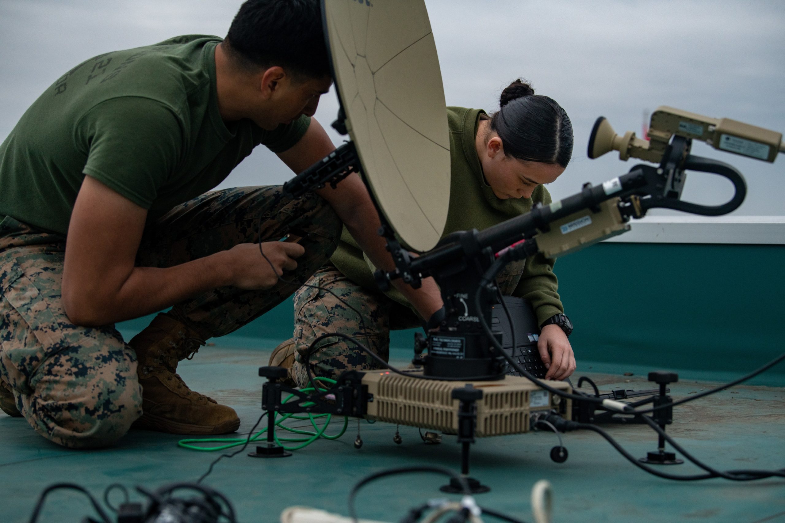 U.S. Marine Corps Lance Cpl. Angel Torres (left) and Cpl. Vanessa Jenkins (right), satellite transmissions system operators with Marine Wing Communications Squadron 18, configure a Multi-Mission Terminal satellite dish at Hyakuri Air Base, Japan, Dec. 6, 2021. Marines with MWCS-18, Marine Fighter Attack Squadron 112, Marine Wing Support Squadron 171, and Marine Aviation Logistics Squadron 12 are operating at Hyakuri Air Base as part of an Aviation Training Relocation Program. (U.S. Marine Corps photo by Cpl. Evan Jones)