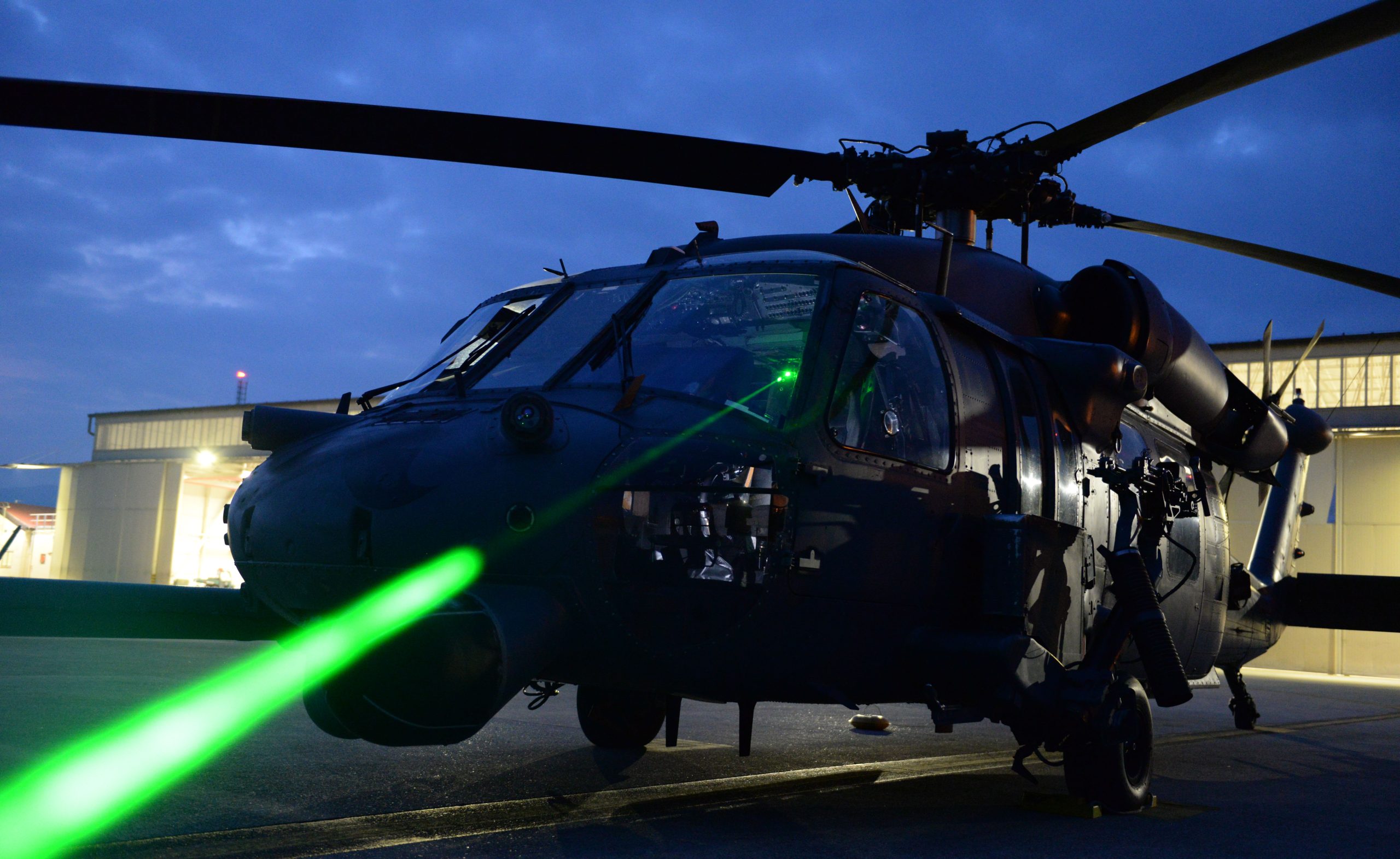 U.S. Air Force Master Sgt. Miguel Gibson, 31st Fighter Wing flight safety manager, demonstrates how pointing a laser at an HH-60 Pave Hawk can illuminate the cockpit at Aviano Air Base, Italy, October 12, 2023. Laser strikes on aircraft, often referred to as 