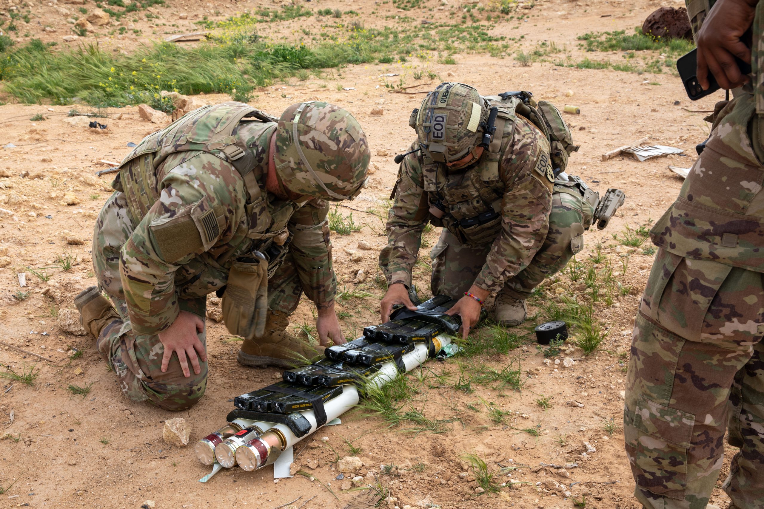 U.S. Army Soldiers assigned to Task Force Redleg add blocks of C4 explosives to rocket motors to create a demolition shot in preparation for a controlled detonation exercise near Al Asad Air Base, Iraq, March 19, 2025. The purpose of the range was to destroy unserviceable munitions to reduce risk allowing the Coalition to better support future operations. These skill sets allow Coalition members to be effective force multipliers by mentoring and developing partner force capabilities to defeat ISIS and maintain regional security and stability. (U.S. Army photo by Sgt. Ryan Ahmed)