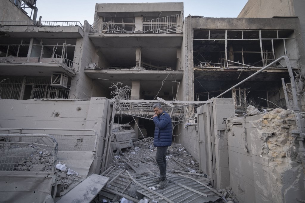 An Iranian man stands in front of destroyed buildings near a police headquarters that is completely destroyed in U.S.-Israeli attacks in Tehran, Iran, on March 2, 2026.