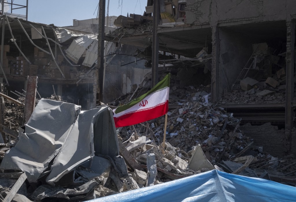 A national flag is photographed on the ruins of a police station that is struck during US-Israeli attacks in Tehran, Iran, on March 3, 2026.
