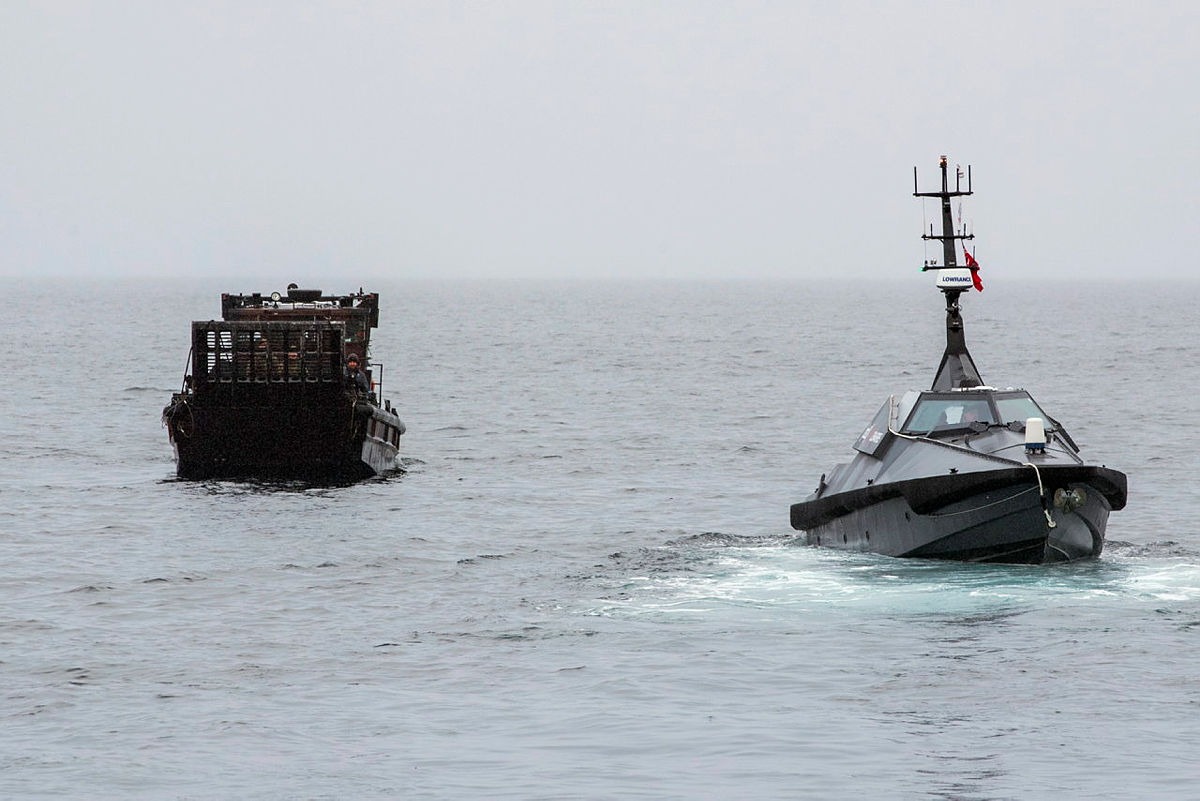 An autonomous surface vessel sea drone intercepts a cargo boat during a UK maritime security operation on open water
