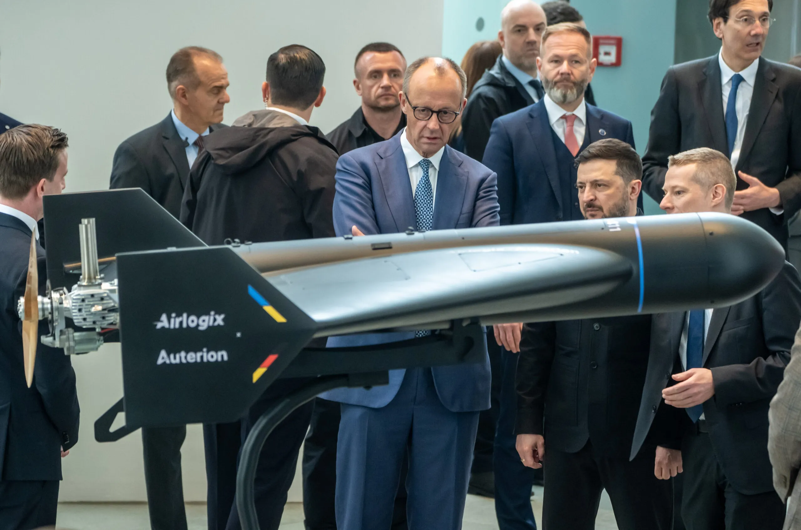 Auterion CEO Lorenz Meier, Airlogix CEO Vitalii Kolesnichenko, Ukrainian President Volodymyr Zelenskyy, and German Chancellor Friedrich Merz with an Airlogix autonomous strike system.