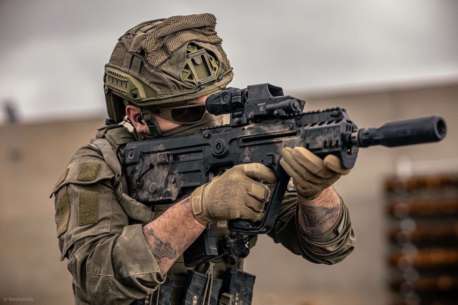 A personnel aiming an X95 rifle