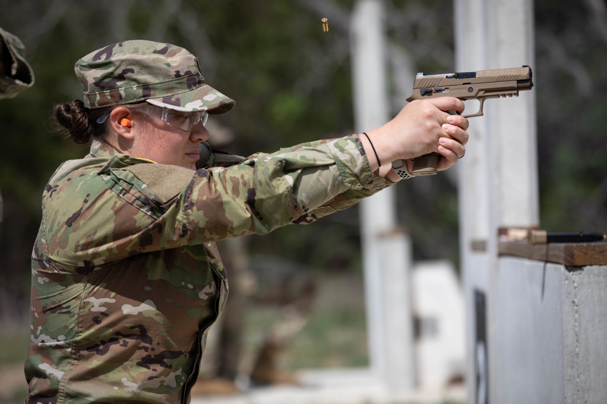 U.S. Army 1st Lt. Amanda Lee, fires the SIG Sauer P320-M17, semi-automatic pistol while kneeling during weapons qualification at Camp Bullis in San Antonio, Texas, on April 19, 2021. The Contract Operational Readiness Exercise culminating events validates Soldiers set to deploy within the coming months and next fiscal year (U.S. Army photo by Spc. Eric Kestner / Released by Ms. Angele Ringo 377th Public Affairs Specialist).